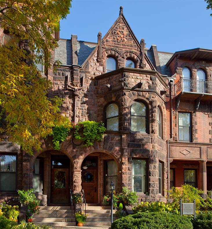 large Victorian house with arched entryway and rounded, two-story by window