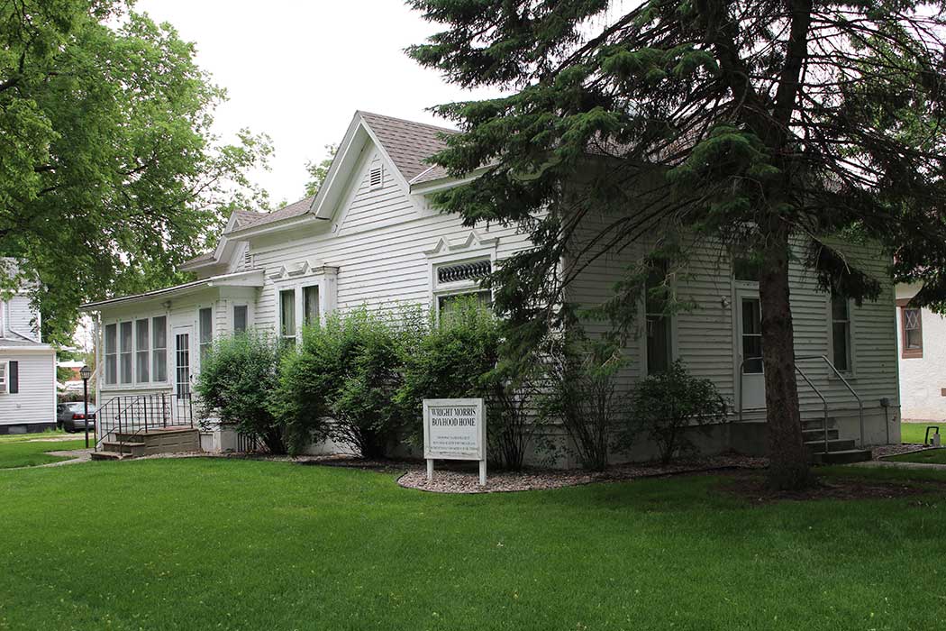 Wright Morris Boyhood Home: white house with green shrubs and trees