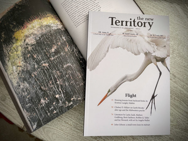 magazine cover with great egret sits on top of open magazine featuring art and poetry