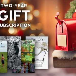 A cozy holiday scene in the background of a graphic that says "two-year gift subscription" with four copies of the handsome New Territory magazine pictured below the text.