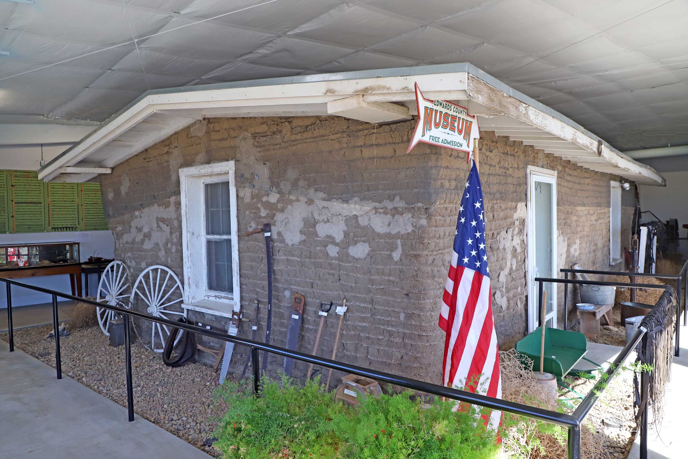 sod house museum with an American flag in the front corner