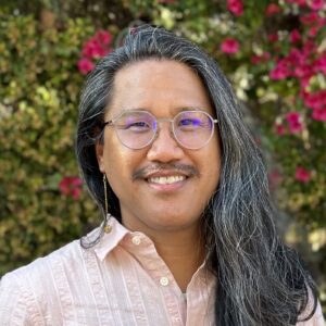 professor portrait in front of rose bushes