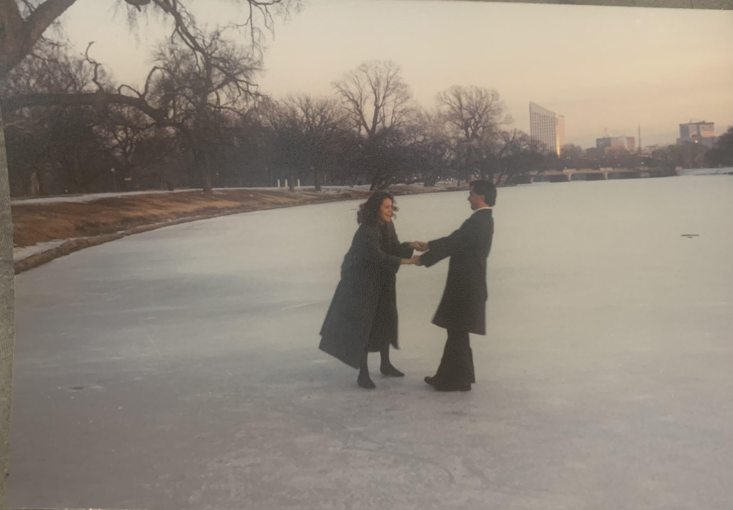 Two people ice skating on a frozen Arkansas River in Wichita, Kansas