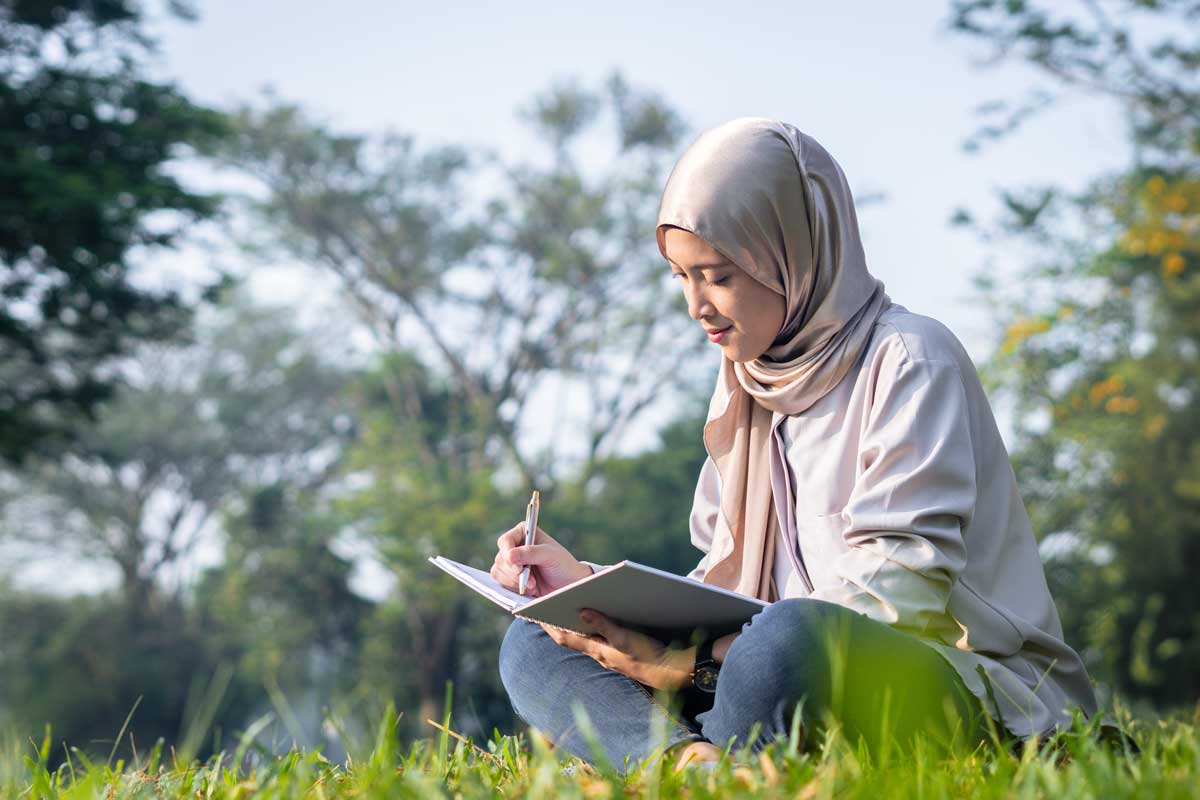 woman writing in grass