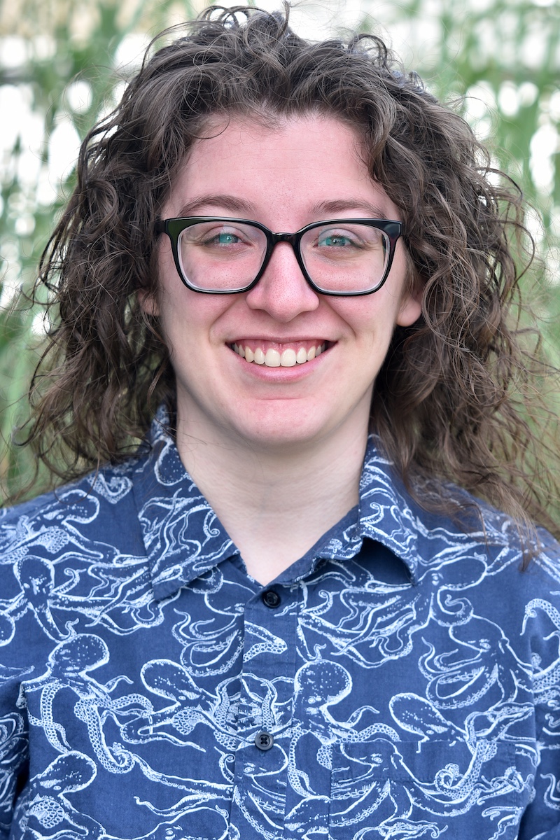 woman smiling wearing a collared shirt covered in octopuses